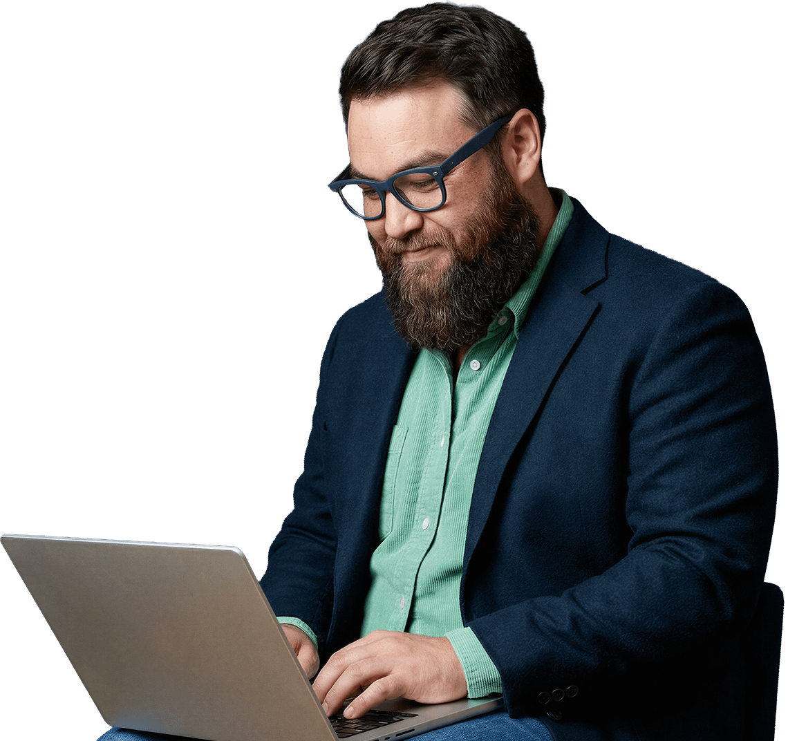 idc-lp-banner-portait Bearded man wearing glasses and blazer working on a laptop