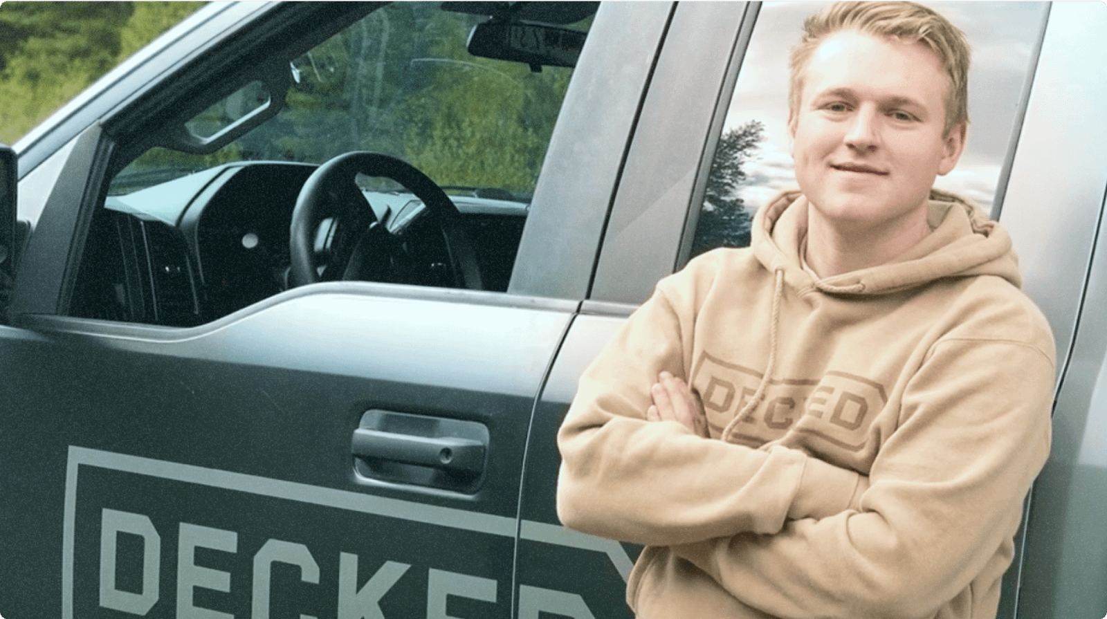 Guy standing next to "Decked" truck