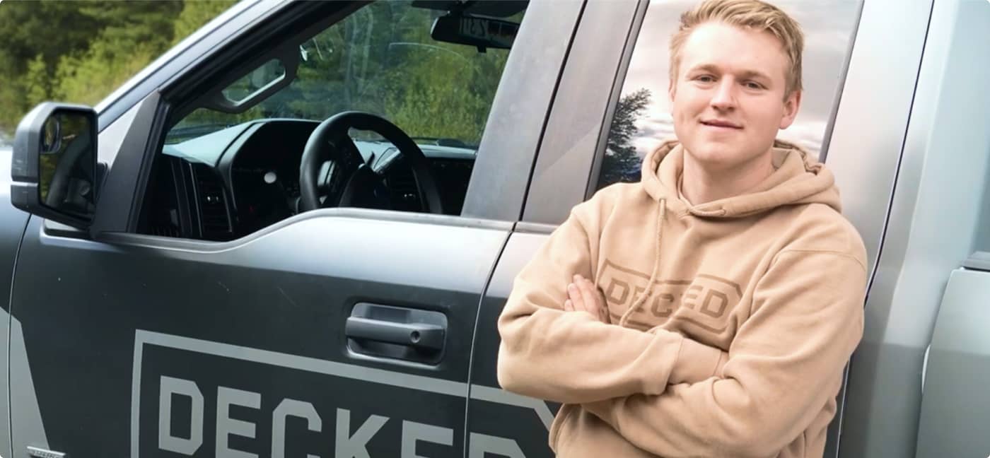 Guy standing next to "Decked" truck