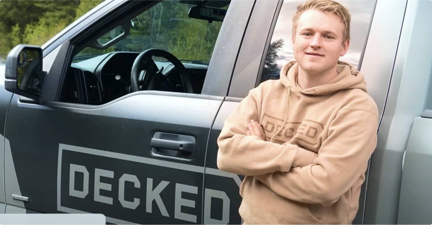 Guy standing next to "Decked" truck